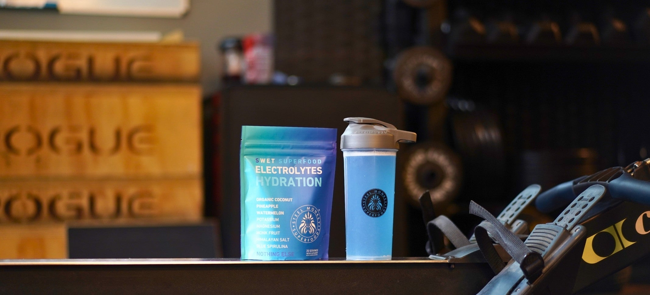 bag of electrolyte powder and a shaker sitting on a rower machine